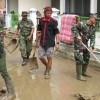 Anggota Kodim 0615 Kuningan beserta warga saat membersihkan lumpur pasca banjir di Cibingbin.